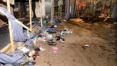 Clothes and shoes scattered on a muddy street after a stampede in Kolkata.