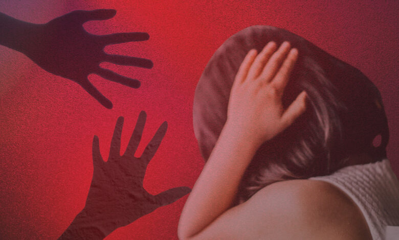 Child shielding face from shadowy hands representing online abuse risks.