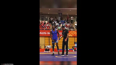Nitesh shaking hands with referee during Greco-Roman wrestling match at Asian Games.