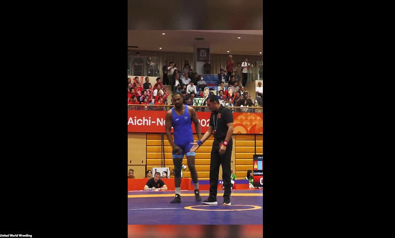 Nitesh shaking hands with referee during Greco-Roman wrestling match at Asian Games.