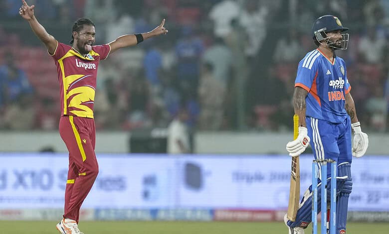 Cricket player celebrating with arms outstretched during match at the stadium.