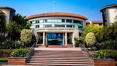 Oakridge International School Gachibowli building with lush greenery and clear blue sky.