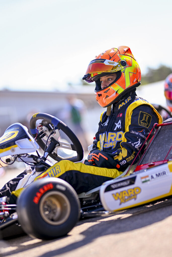 Indian kart racer Atiqa Mir in racing gear with kart at the track.