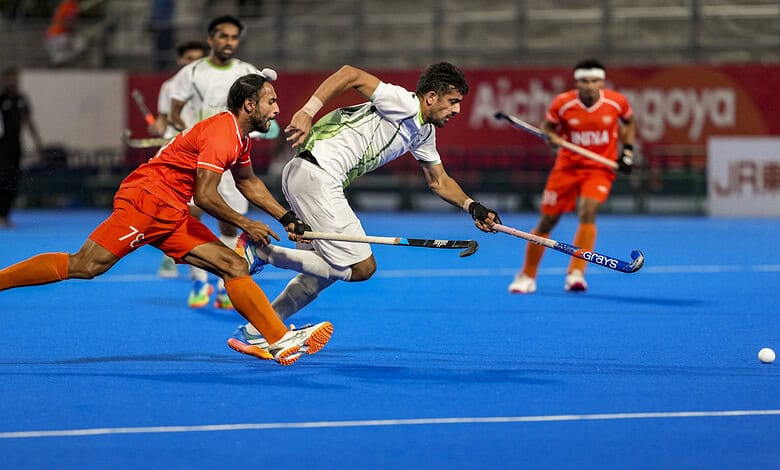 India and Pakistan hockey players compete fiercely during an Asian Games match.