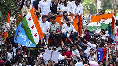Protesters gather on a vehicle with Indian flags during a demonstration in Delhi.
