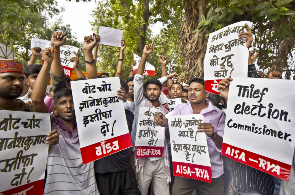 Protesters in Patna hold signs demanding CEC's resignation during a rally.