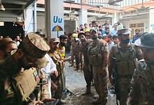 Pakistani rescue workers and civilians at the site of school roof collapse, many injured and waiting for救.