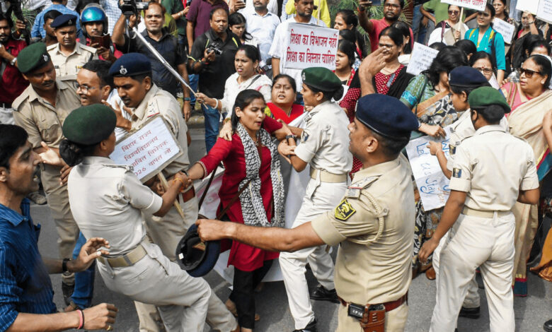 Protest march in Patna with women protesters and police officers clashing.