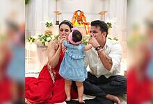Prince Narula and Karishma react joyfully to their child during a festive celebration.