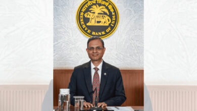 Reserve Bank of India official in formal attire at a press conference or event.