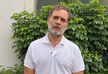 Rahul Gandhi speaking outdoors with greenery in the background.