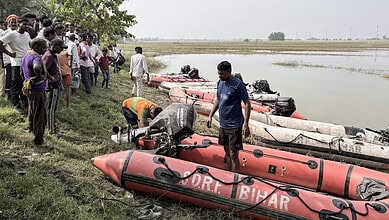Rescue operation with boats on a riverbank in Bihar amid ongoing search efforts.
