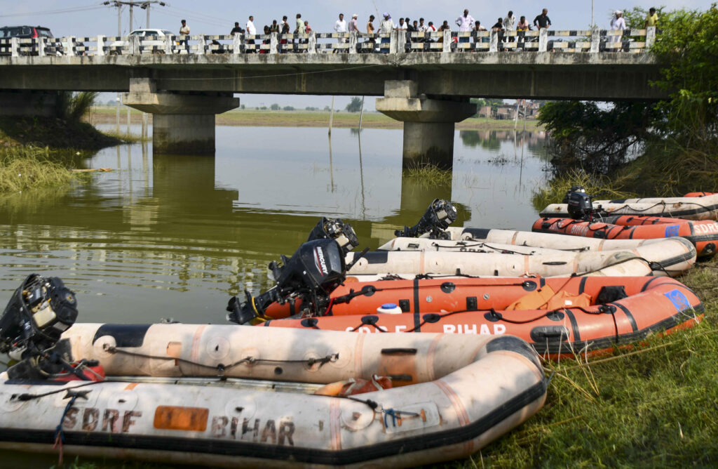 Rescue boats docked near a riverbank during Bihar boat capsize rescue efforts.