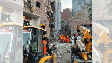 Rescue operation at building collapse site in Seemapuri, Delhi with firefighters and heavy machinery.