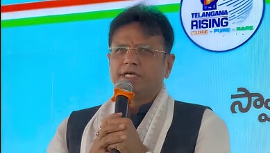 Sridhar Babu speaking at a public event with a microphone in hand.