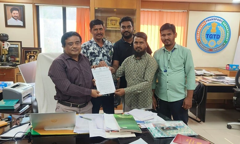 Group of men holding a document in an office with transport union logo in background.