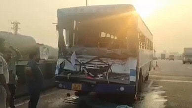 Damaged bus after collision on Hyderabad outskirts during sunset.