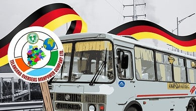 German bus with a flag and a logo promoting overseas manpower and community development.