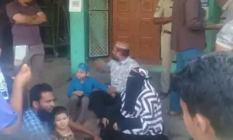 Protest outside husband's home with women and children gathered in Telangana, India.