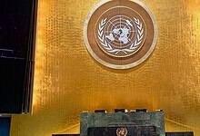 United Nations emblem displayed on a golden wall at the UN headquarters.