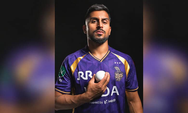Cricketer Umran Malik in a purple jersey holding a cricket ball, looking serious.