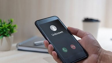 Mobile phone displaying an incoming call from an unknown caller.