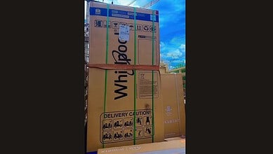 Large cardboard boxes stacked on a truck, secured with straps, ready for delivery.