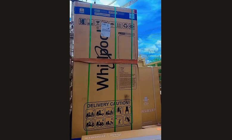 Large cardboard boxes stacked on a truck, secured with straps, ready for delivery.