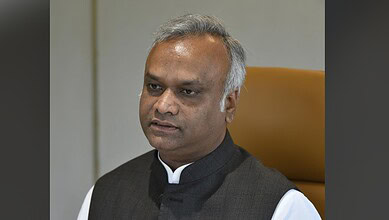 Priyank Kharge in a formal setting, wearing a black vest over a white shirt.