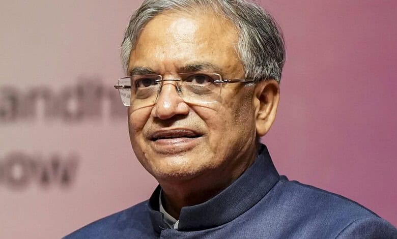Senior man with glasses in a formal blue outfit at a public event.
