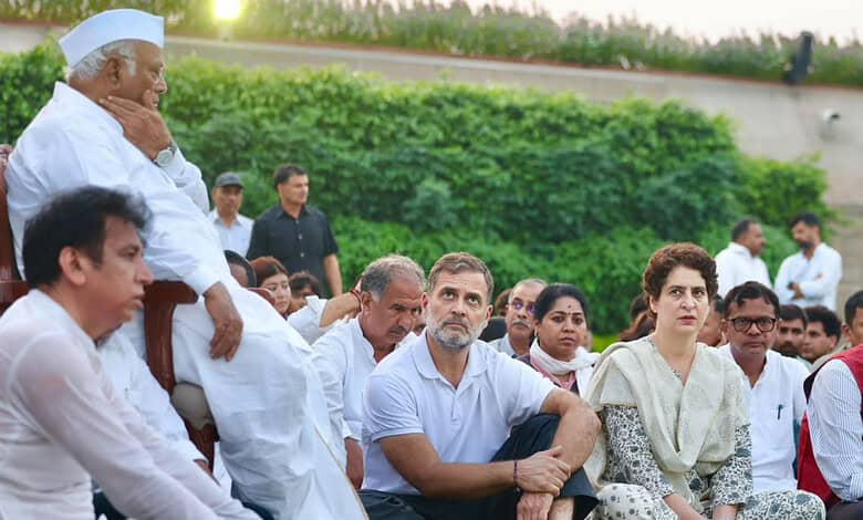 Congress leaders gathered at Rajghat for a protest against election vote theft, sitting on the grass.