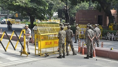 Delhi police officers and barricades at a protest site in Delhi during a detention incident.