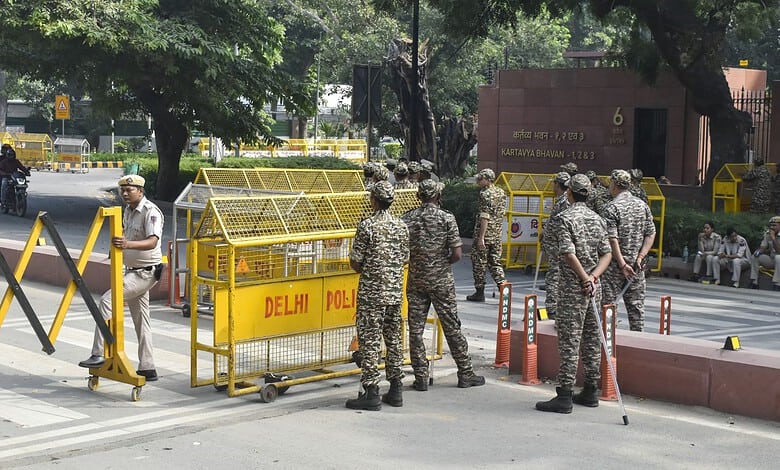 Delhi police officers and barricades at a protest site in Delhi during a detention incident.