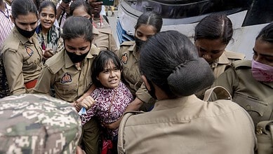 Young girl confronts police officers during a protest in Delhi, India.