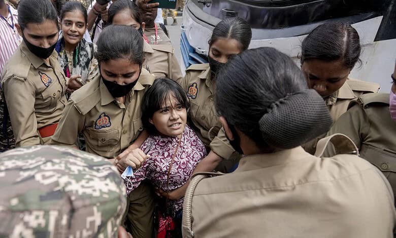Young girl confronts police officers during a protest in Delhi, India.
