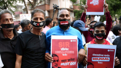 Protesters with masks hold signs during Nagpur anti-CEC protest, demanding justice.