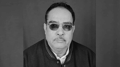 Black and white portrait of a man wearing sunglasses and a jacket.