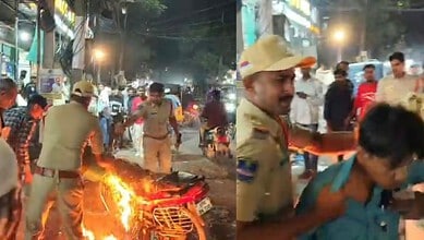 police personnel douse flames on the bike