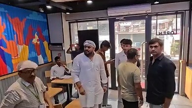 Group of people inside Domino's restaurant with some waiting and others ordering food.