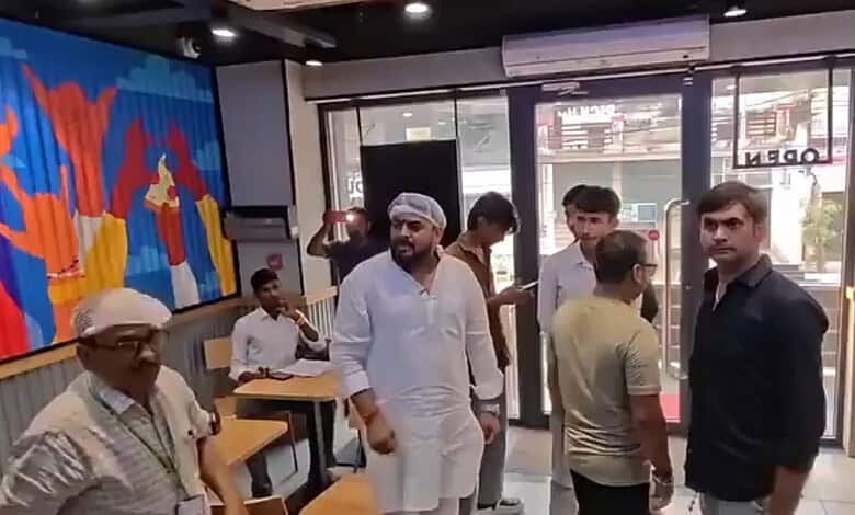Group of people inside Domino's restaurant with some waiting and others ordering food.