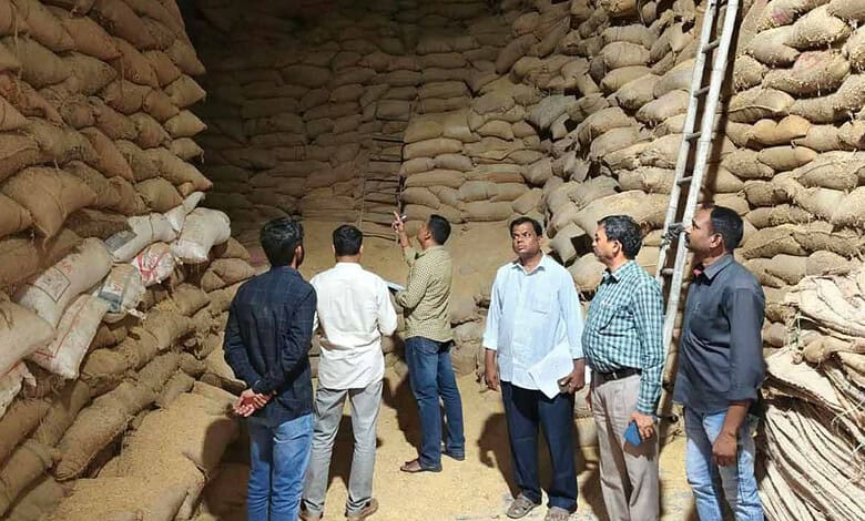 Group of men inspecting a large storage of rice sacks in a warehouse.