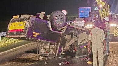 Accident scene with overturned vehicle and emergency responders at night.