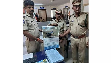 Telangana Forest Dept officials display a poster about Indian Roller conservation at a public event.
