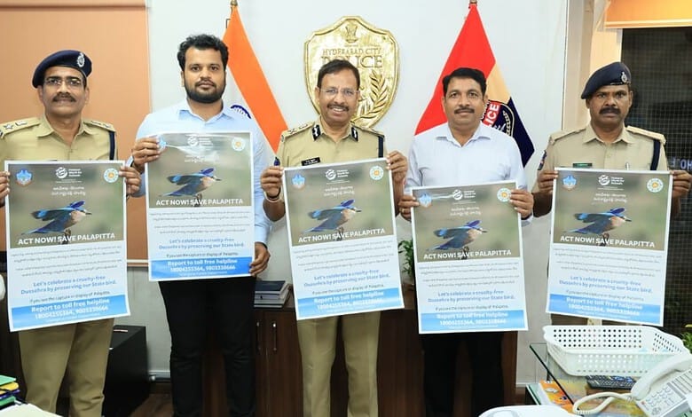 Hyderabad police officials hold posters during a campaign against Indian Roller display.