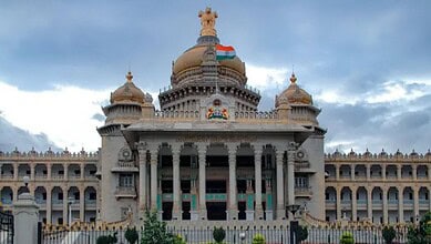 The Karnataka Legislative Assembly building in Bengaluru with cloudy sky background.