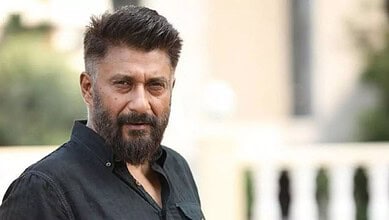 Vivek Agnihotri with a serious expression outdoors, wearing a black shirt.