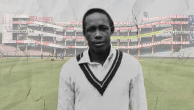 Cricketer in cricket stadium with empty stands, black and white image.