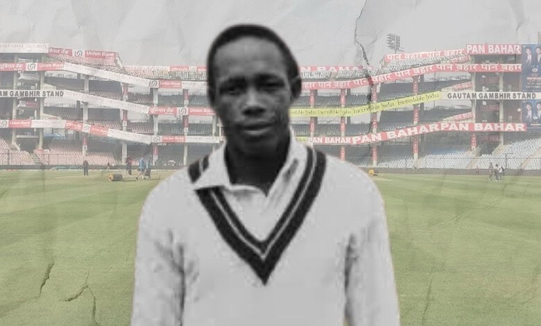 Cricketer in cricket stadium with empty stands, black and white image.