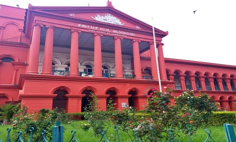 Historic red building with columns and a garden in front, under a clear sky.
