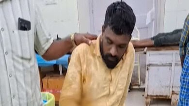 Man receiving medical attention in a clinical setting with healthcare workers present.